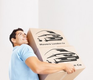 Moving in apartment - Smiling young man carrying cardboard boxes